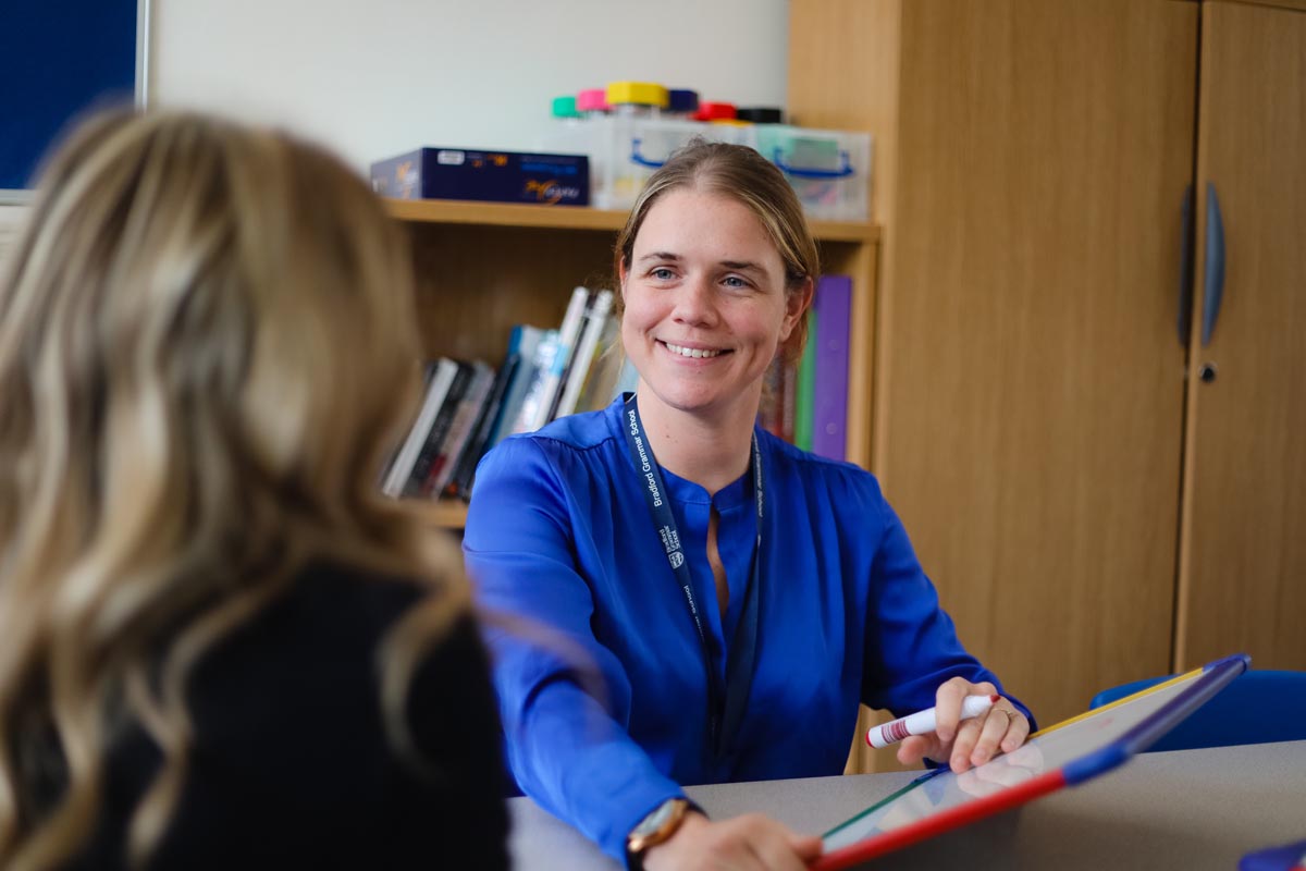 Laura Johnson, Head of Learning Strategies and Special Education Needs and Disabilities Coordinator showing a whiteboards to a pupil.