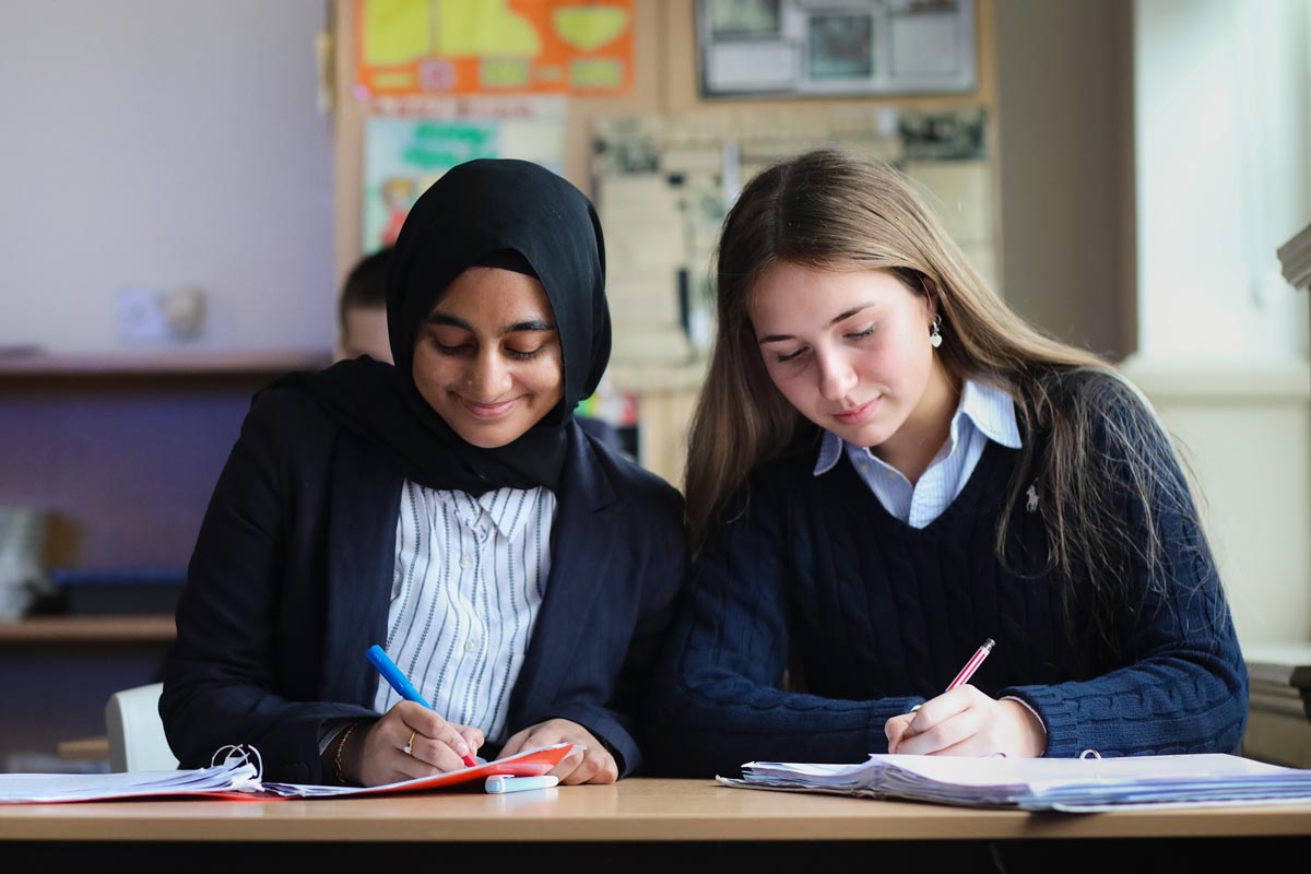 Year 13 students Nida and India working in a classroom.