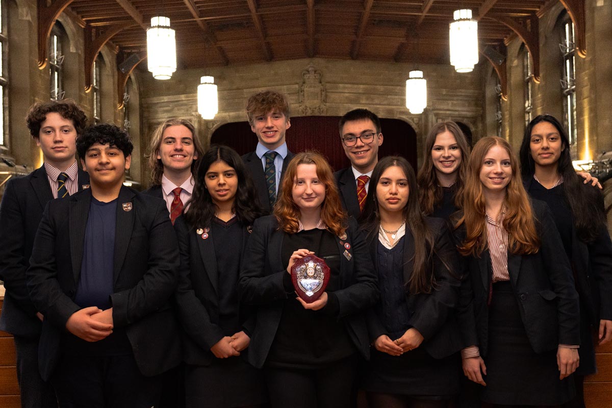 A group of students proudly holding a trophy